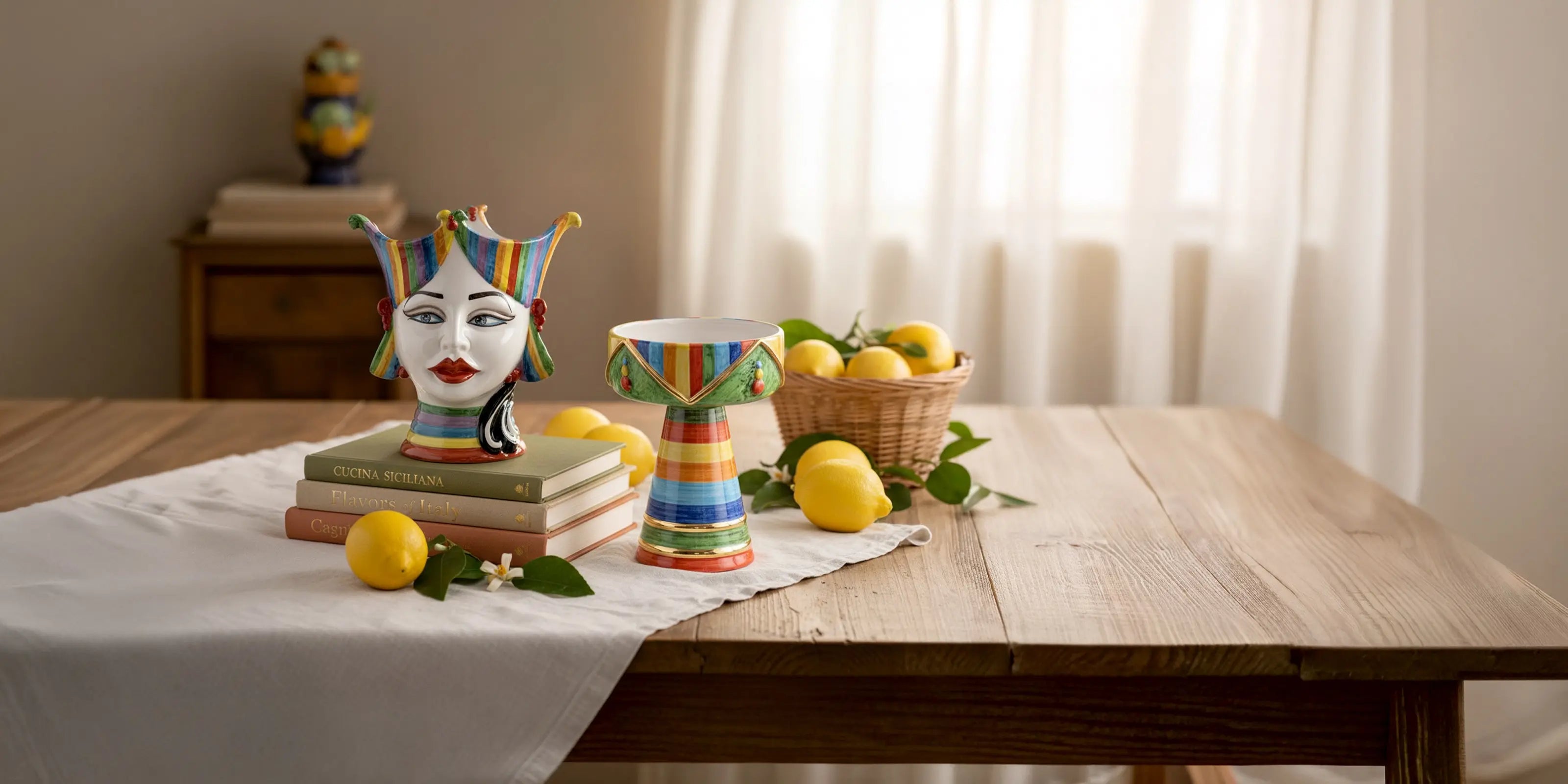 Ceramiche Caltagirone fatti a mano colorate su tavolo con limoni e libri, stile artigianale siciliano.