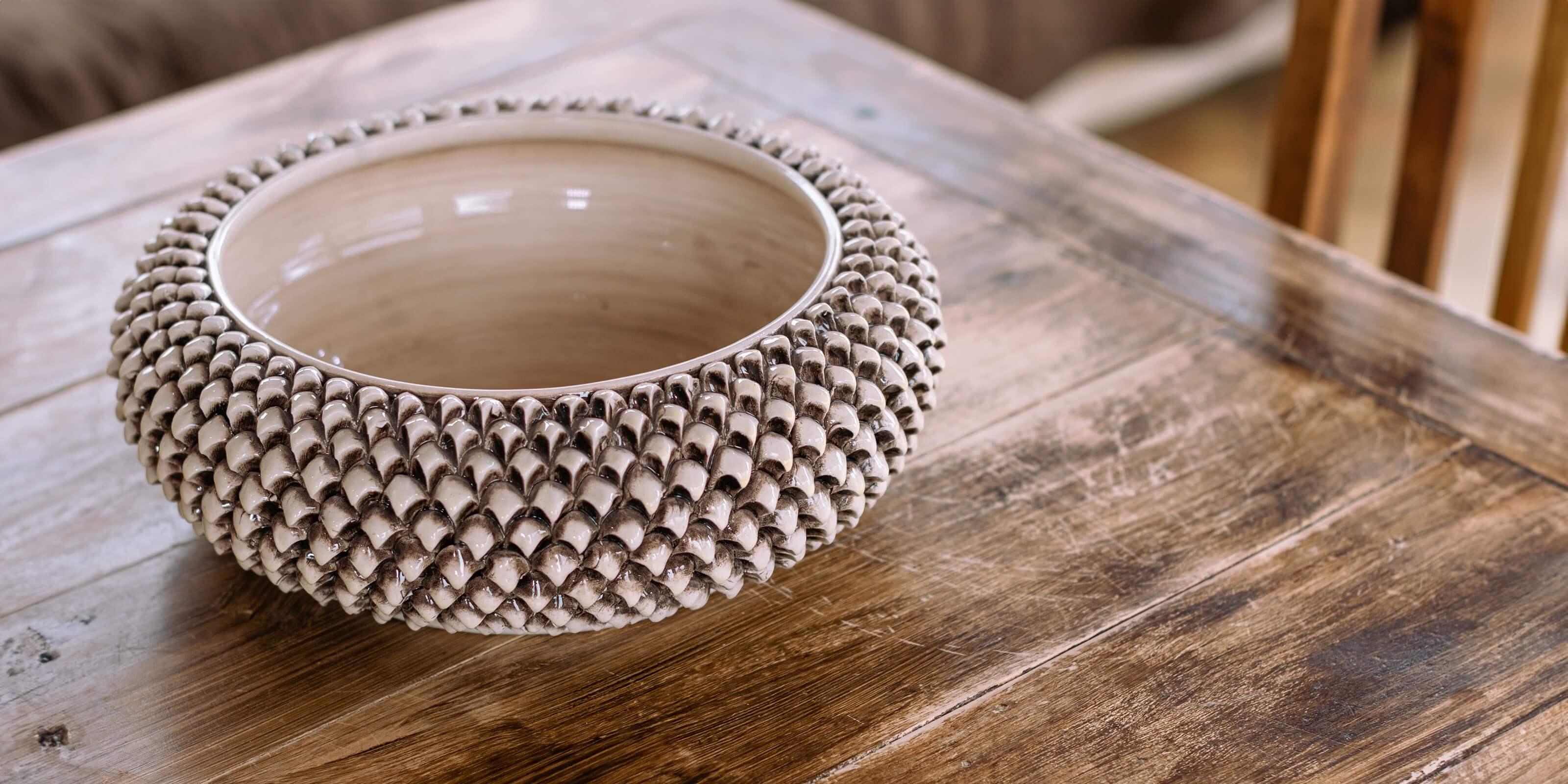 Centrotavola a forma di pigna in ceramiche di Caltagirone fatti a mano su tavolo di legno rustico