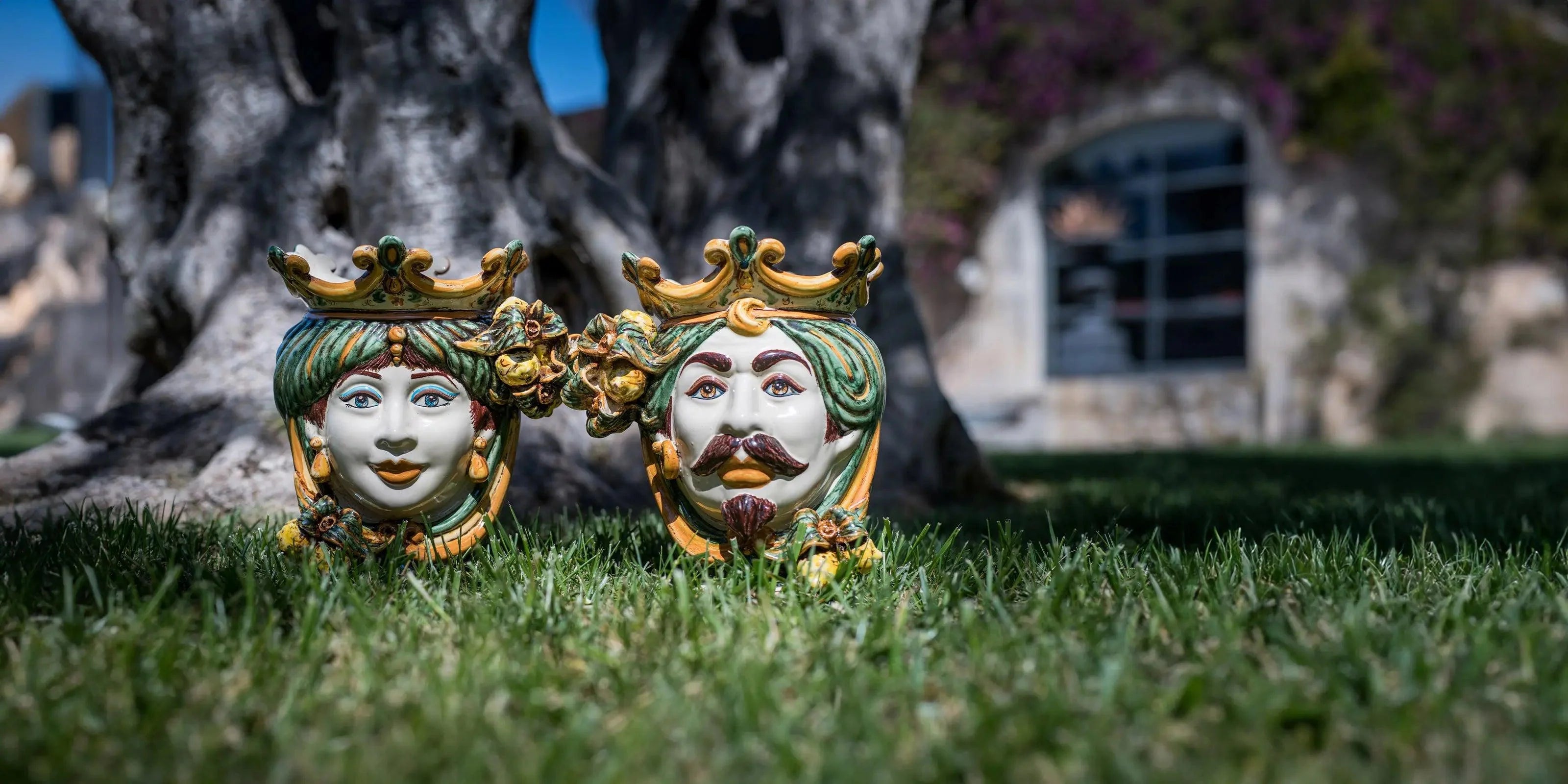 Teste di moro ceramiche di Caltagirone Sofia fatti a mano in verde e arancio su prato