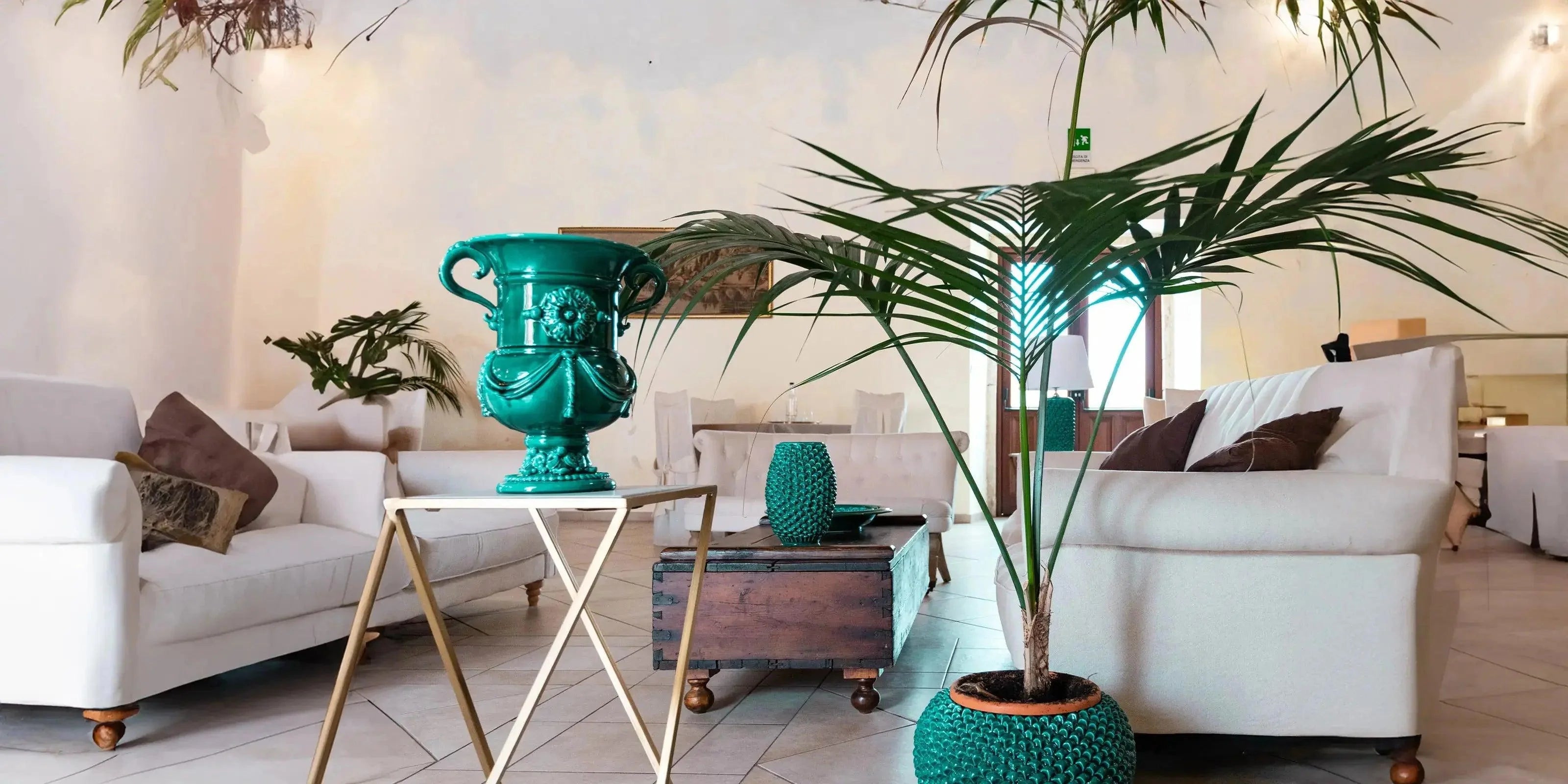 Soggiorno moderno con divani bianchi e ceramiche Caltagirone fatti a mano in verde smeraldo