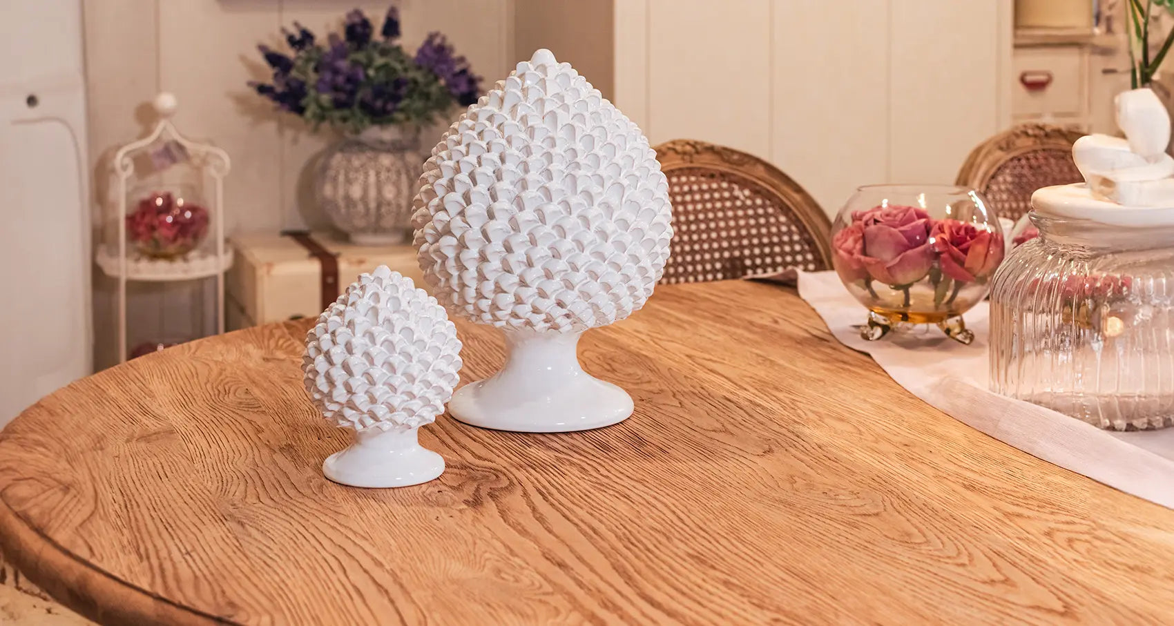 Pigne bianche ceramiche Caltagirone fatti a mano su tavolo in legno, ambiente elegante