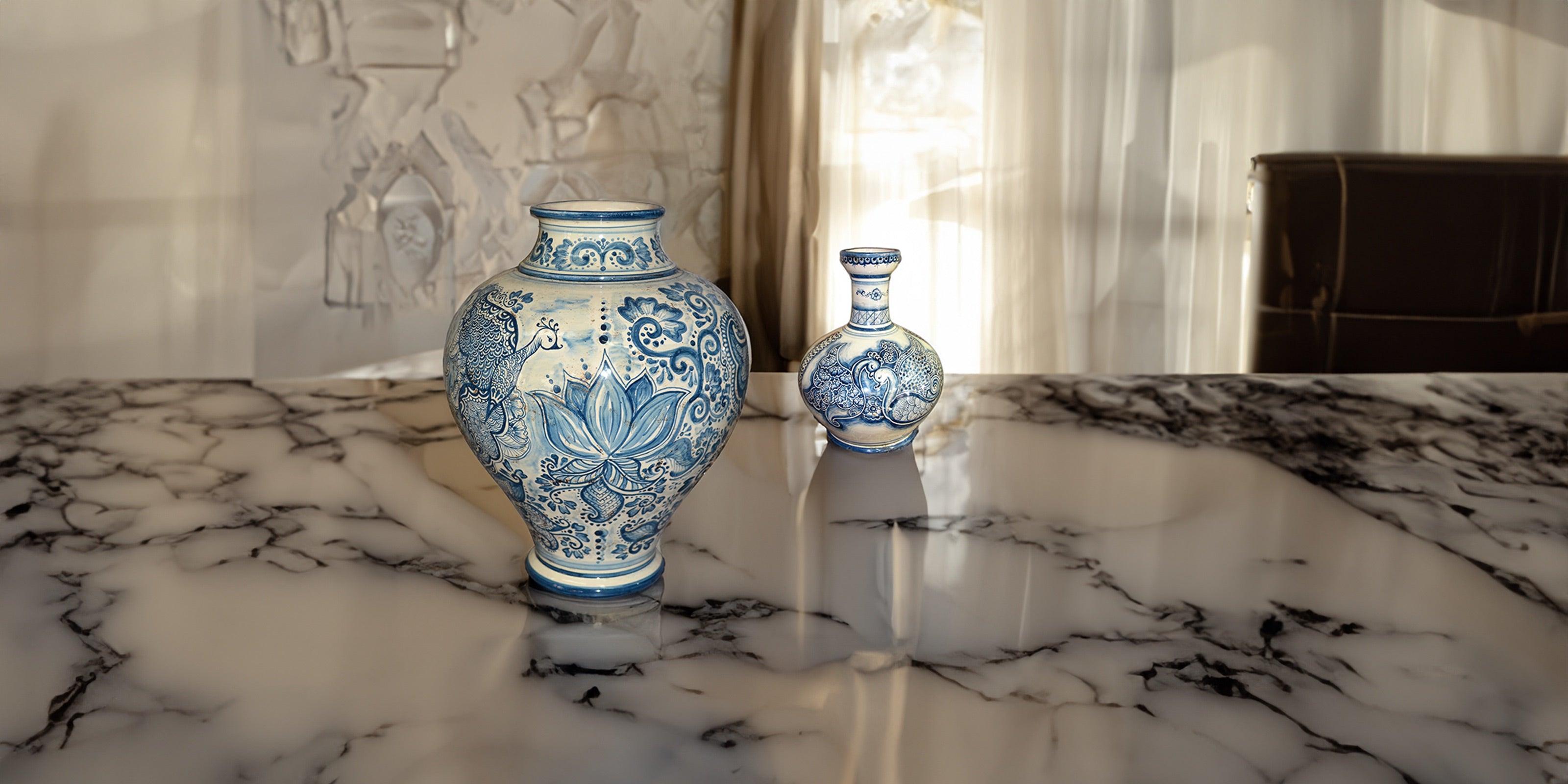 Due vasi in ceramica di Caltagirone fatti a mano con decorazioni blu su un tavolo in marmo