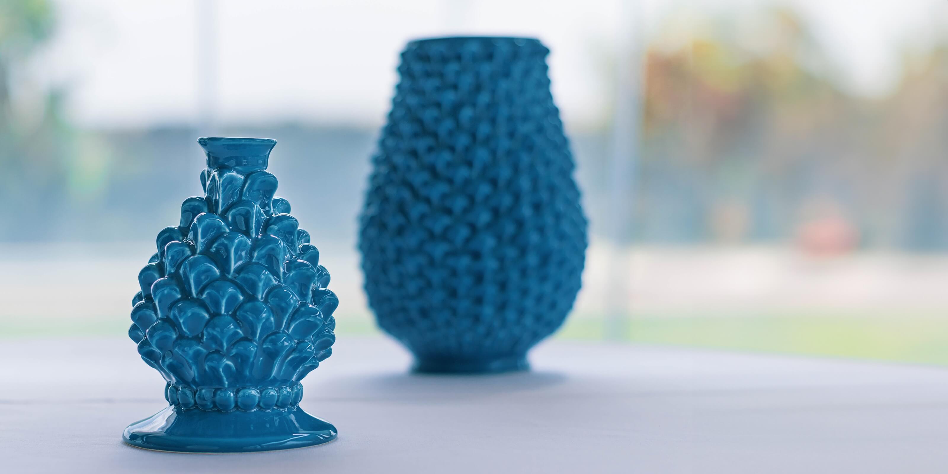 Portacandela a pigna blu ceramiche Caltagirone fatti a mano su tavolo, stile artigianale.