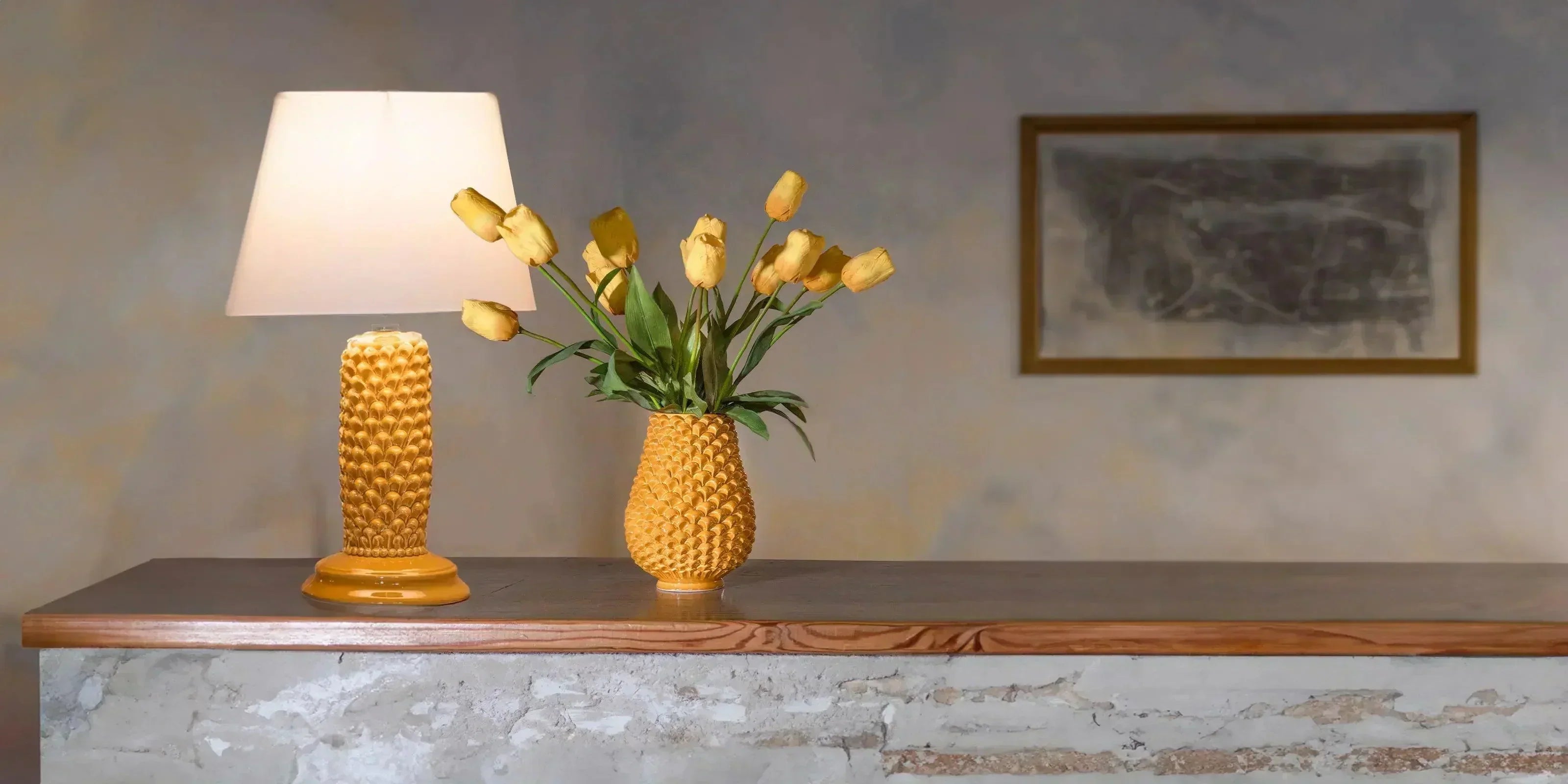 Lampada e vaso in ceramiche Caltagirone fatti a mano con fiori gialli su tavolo in legno