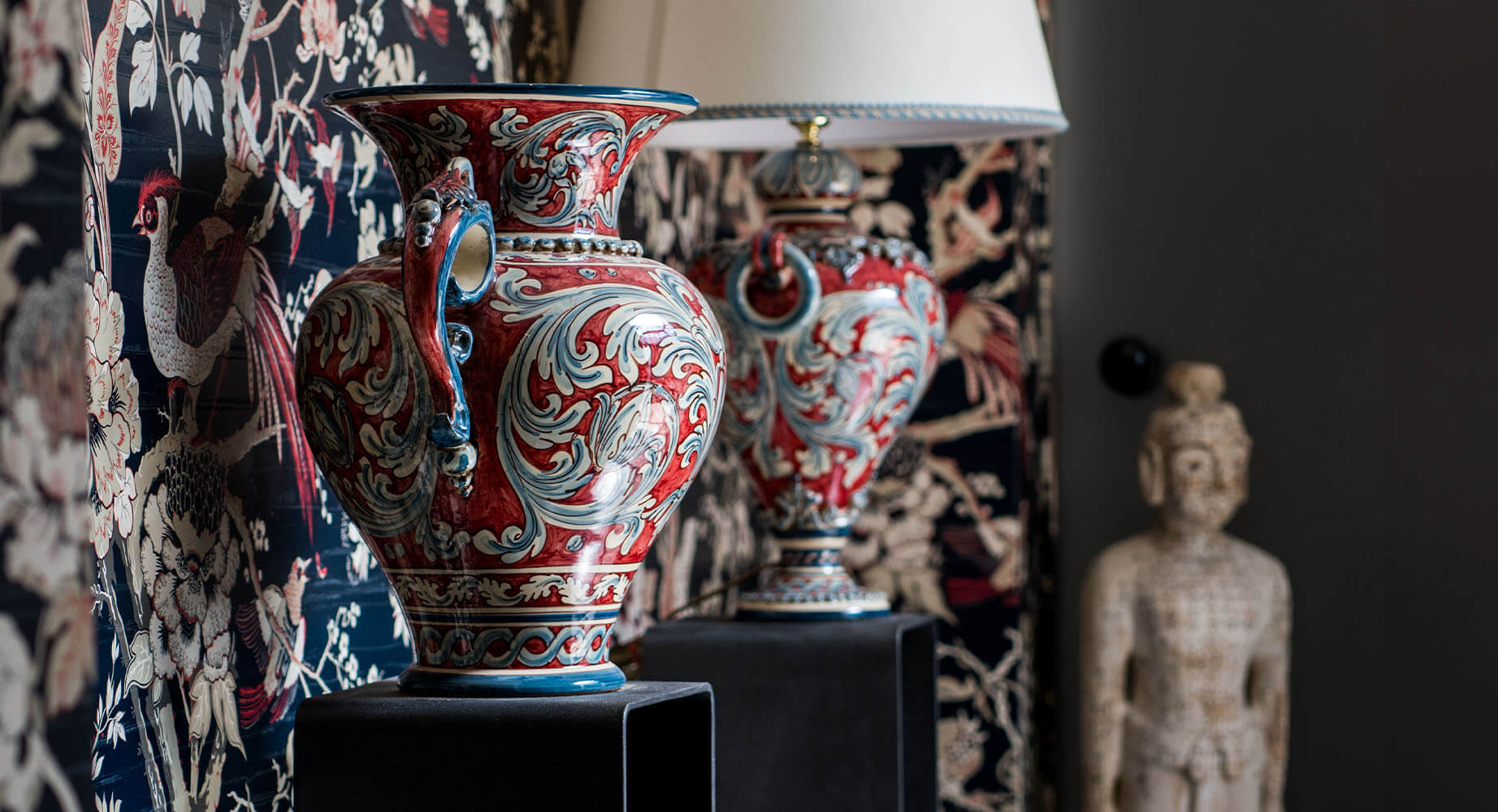 Vasi ceramiche Caltagirone fatti a mano decorati con motivi floreali rossi e blu su sfondo elegante.