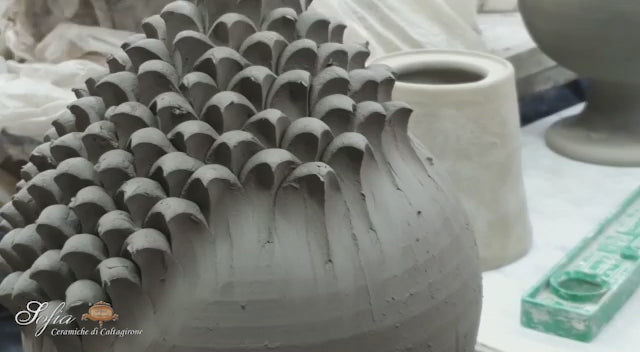 Video della realizzazione della pigna in ceramica, ogni spicchio viene applicato a mano su una base fatta al torneo