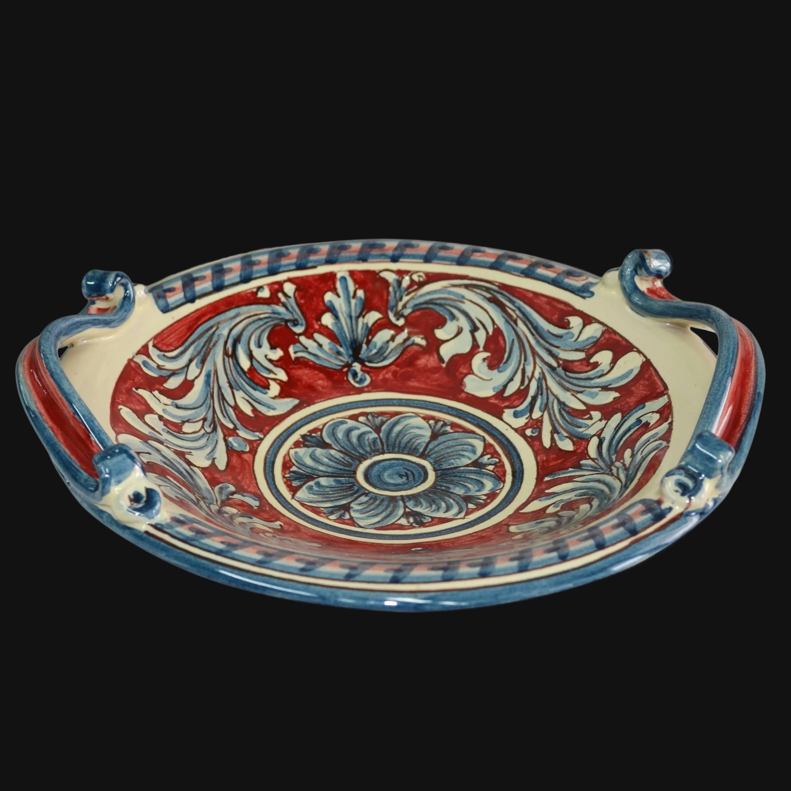 Ceramiche di Caltagirone fatti a mano con decori blu e rossi su fondo crema, stile tradizionale siciliano