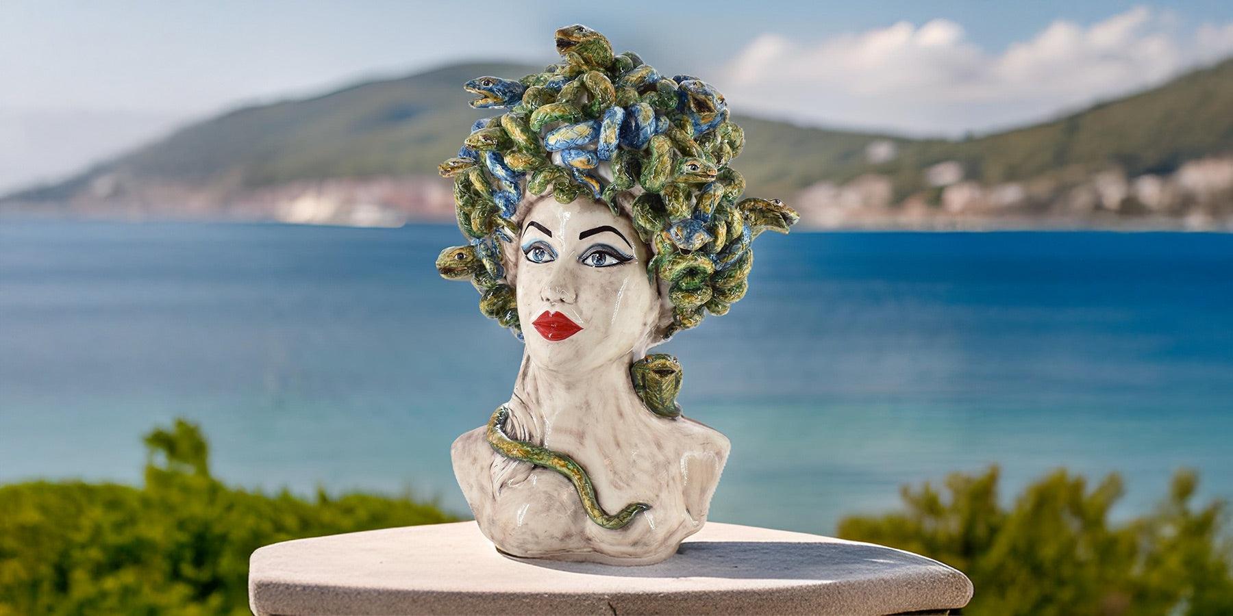 Busto in ceramica di Caltagirone fatto a mano raffigurante Medusa con capelli di serpenti, sullo sfondo mare e colline