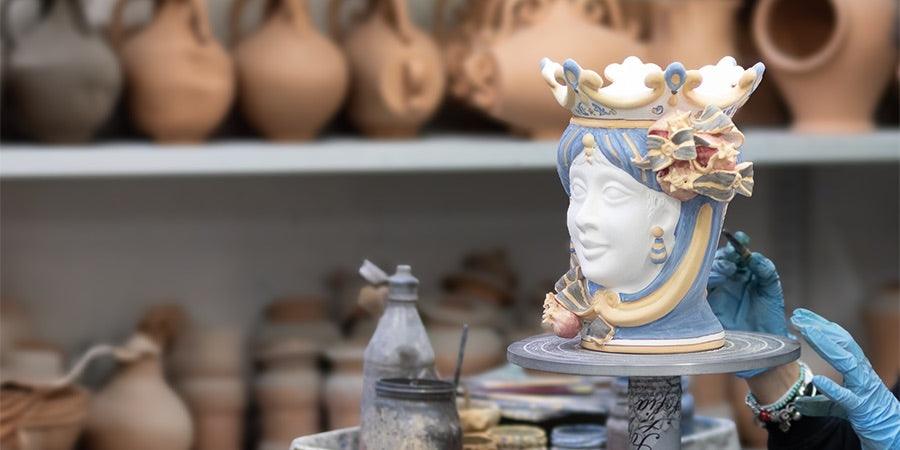 Ceramiche Caltagirone fatti a mano, testa decorativa in ceramica con dettagli colorati in laboratorio